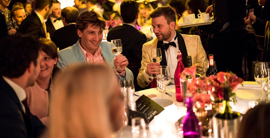 Groep heeft diner aan tafel en heft het glas bedrijfsuitje